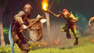Player blocking with a shield while holding a torch against a goblin, showing melee combat